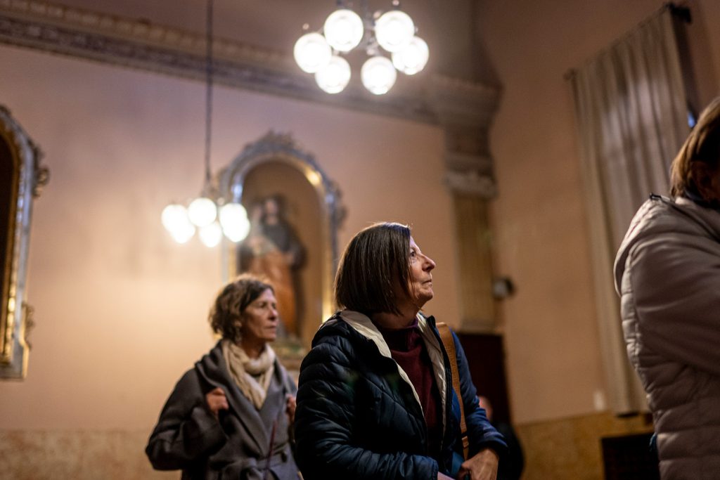 Persone che stanno assistendo all'Opera ExClausura all'interno del Monastero.